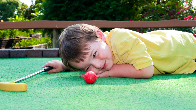 Child playing mini golf